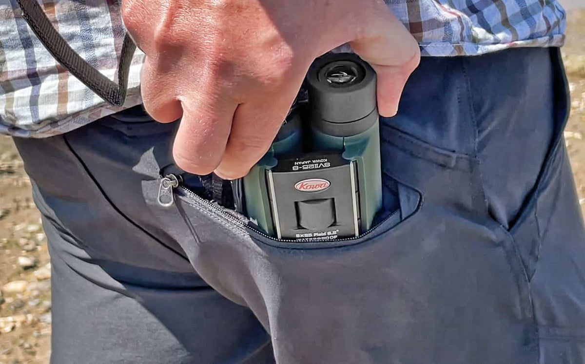 Uomo inserisce binocolo Kowa SV II 10x25 in tasca esterna.