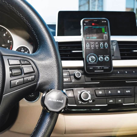 Alt Tag: Dispositivo Midland PTT Dual su cruscotto auto per comunicazione mani libere tramite APP CB Talk. Sicurezza guida senza sanzioni.